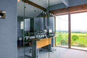 13, Single glazed frameless partitioning cut and fitted around the window lintel